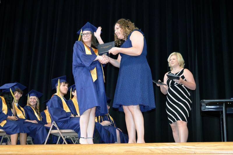 Polo Community High School senior Raquel Patitucci waves to her family as she accepts her diploma from PCHS Board of Education member Jennifer Grobe during the Class of 2024's commencement ceremony on Sunday, May 19, 2024.