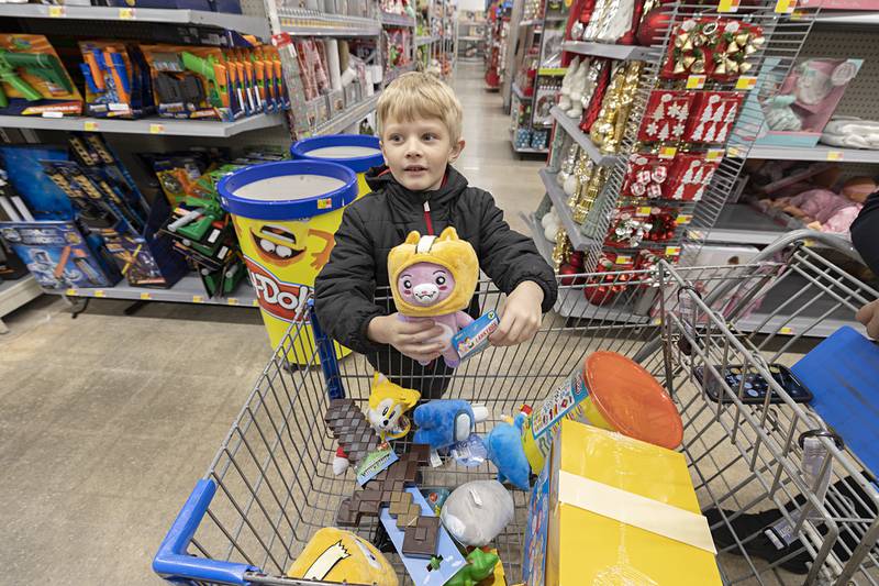 Carter Burmeister, 6, displays his favorite item so far while shopping with Sterling police officers Saturday, Dec. 10, 2022 at the Sterling Walmart. Each child was allowed $250 to pick out Christmas items for themselves and their loved ones during the experience.