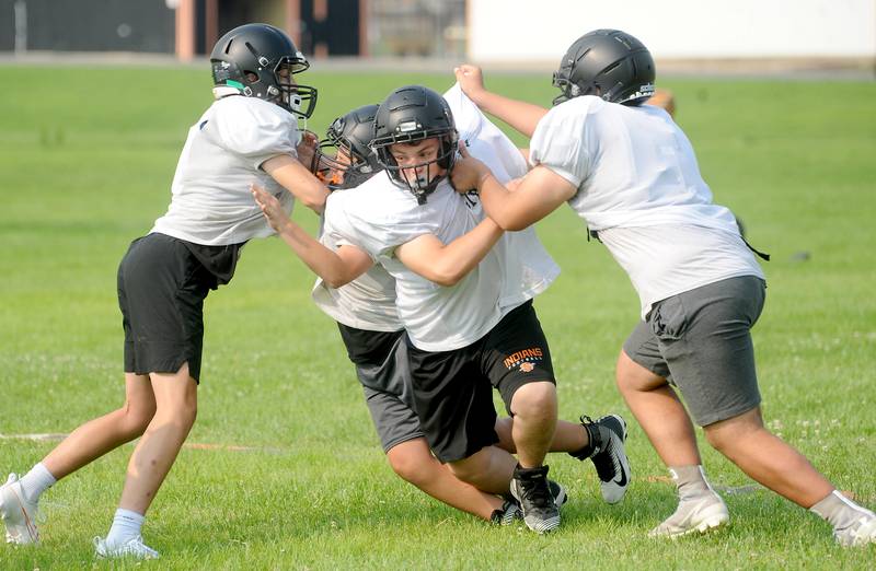 Defensive and offensive linemen work on blocking and rushing skills during early summer football practice at Sandwich High School on Monday, July 17, 2023.