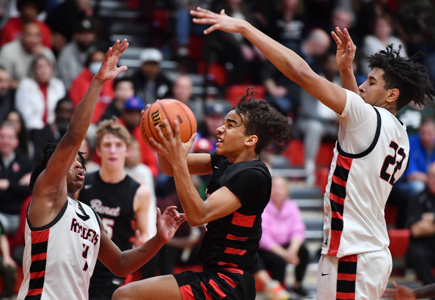 Benet's Blake Fagbemi goes to the basket between Bolingbrook's Kevin Cathey and JT Pettigrew during a Class 4A East Aurora Sectional semifinal game on Feb. 27, 2024 at East Aurora High School in Aurora.