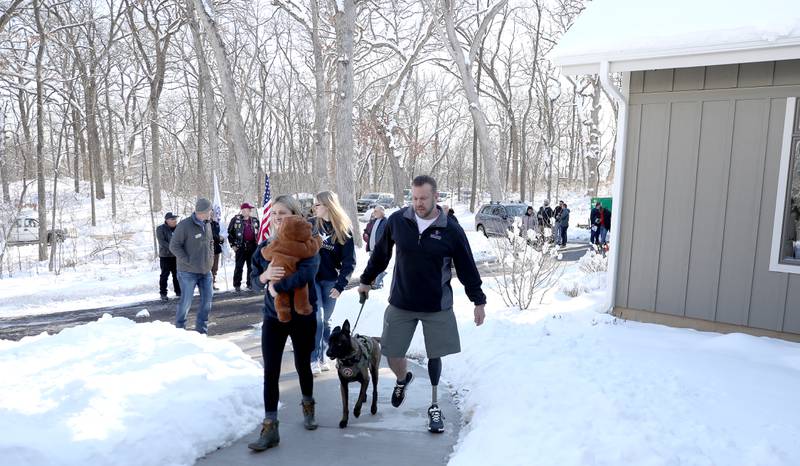 Retired U.S. Army Chief Warrant Officer 2 Patrick Scrogin, along with wife Alexa, service dog, Kiowa, and children Wyatt, Paige and Kaylee, walk to the front door during a dedication for his family’s newly constructed, specially adapted smart home in St. Charles on Thursday, Jan. 18, 2024. The mortgage-free home was made possible by the Gary Sinise Foundation.