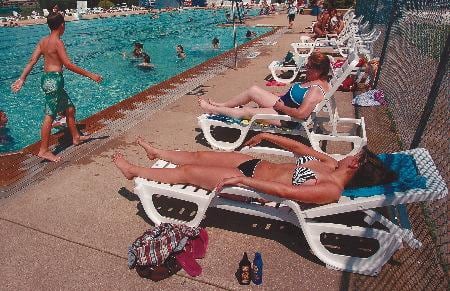 Ashley M. Poskin/Gazette Maureen McKee of Sterling and her granddaughter Katrina Silva sunbathe at Lawrence Park Pool Thursday afternoon in Sterling. McKee had a bout with skin cancer and to be careful, uses SPF 50.