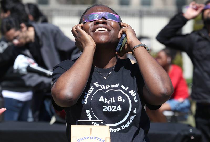 Dorcas Joseph, a Northern Illinois University grad student, watches the eclipse Monday, April 8, 2024, at the NIU Solar Eclipse Viewing Party behind Davis Hall in DeKalb. Attendees were treated to perfect weather to watch the rare celestial event.