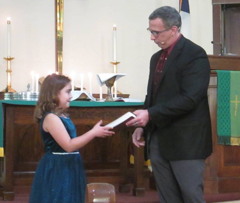 Pastor Stevan Saunders presents an ESV Children’s Bible  to a third grader on Nov. 5, 2023.