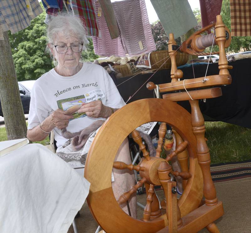 Margaret Jaeger of Barnyard Friend demonstrates the art of spinning yarn at her booth Saturday during the return of Art in the Park at Washington Square in Ottawa.