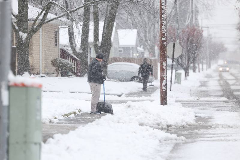 Residents along Vernon Avenue in Joliet come out to deal with the evening snow on Tuesday, Jan. 9th, 2024.