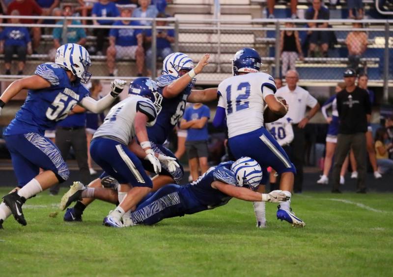 The Princeton defense swarms Newman's Evan Bushman Friday night at Bryant Field. The Tigers won 28-14.