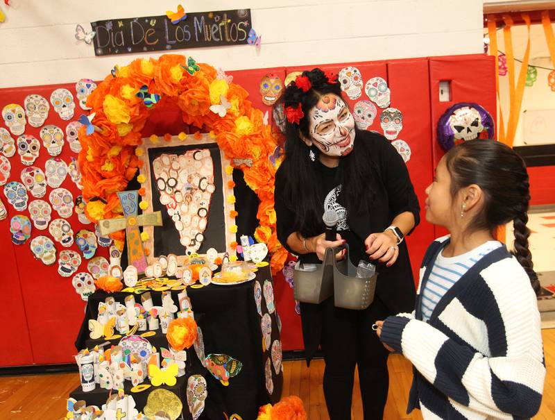 Yesenia Flory talks with Tania Bahena, 10, both of Fox Lake about the picture she made of her grandmother, Julia, and put it on the Lotus Elementary School altar during the Dia de los Muertos, Day of the Dead event at Stanton Middle School on November 4th in Fox Lake. The event was sponsored by the Bilingual Parents Advisory Committee (BPAC) from School Districts 114,124 and 37.
Photo by Candace H. Johnson for Shaw Local News Network