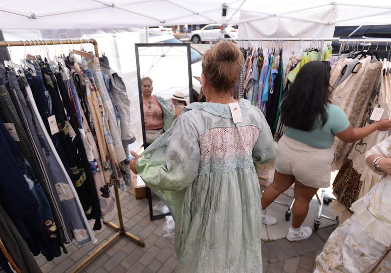 Gretchen Hamilton of LaGrange tries on one a piece of clothing made by Shefaboulors designer at the LaGrange Craft Fair held Saturday, July 13, 2024.