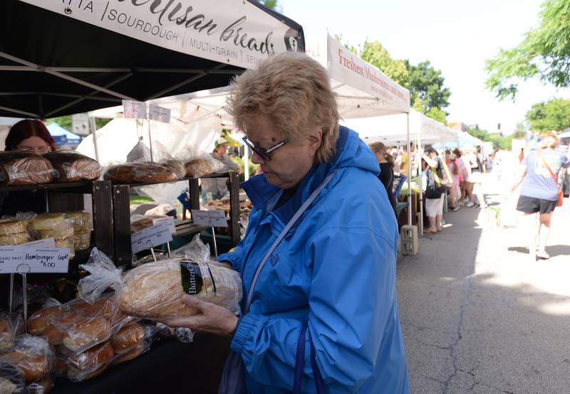 Debby Bagniewski of Lagrange Park looks over some of the breads sold from Hickory Hills Buttercrumb Bakery during the LaGrange Farmers Market Thursday June 7, 2024.