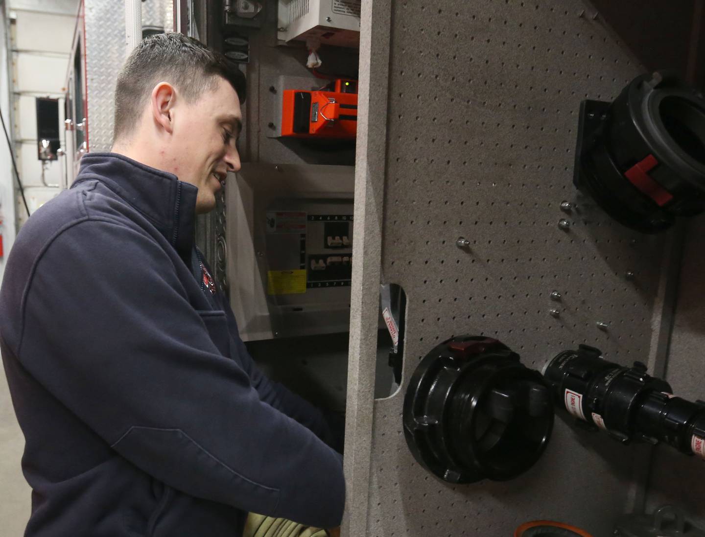 Ottawa firefighter and paramedic Austin Eby, check fire gear on a fire engine at the Ottawa Fire Station off of State Street on Thursday, April 18, 2024 in Ottawa.