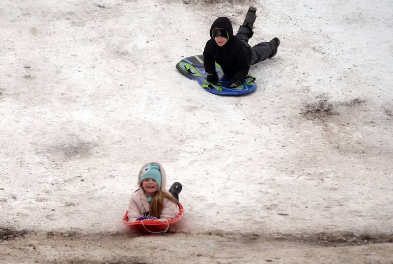 Children including Georgia and Andrzes Kusper of Brookfield fight the cold weather while sledding at Memorial Park in Lagrange Park Saturday, Jan 13, 2024.