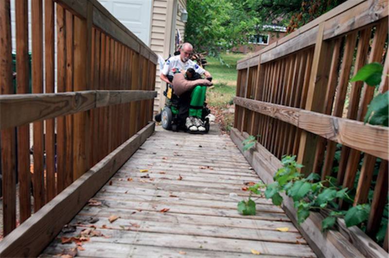 Kerry Neff of McCullom Lake uses a ramp Tuesday to get into his home. Neff became a quadriplegic in a motorcycle accident 21 years ago. He recently received a $20,000 wheel chair after having the same manual one for the past 21 years.