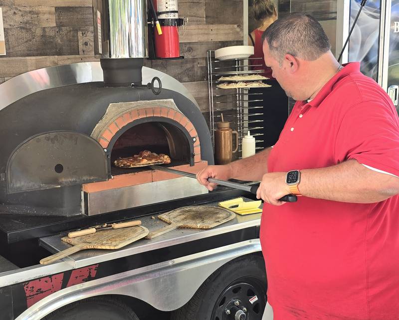 Brick & Ember Wood Fired Pizzeria prepares a fresh pie Saturday, Sept. 14, 2024, during the Fall Food Truck Festival in City Park in Streator.