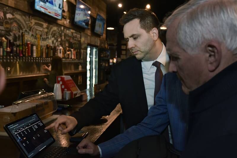 Jerry Evans checks results as they slowly roll in at his election watch party at Global Brew Tap House in St. Charles on Tuesday night, March 19, 2024.