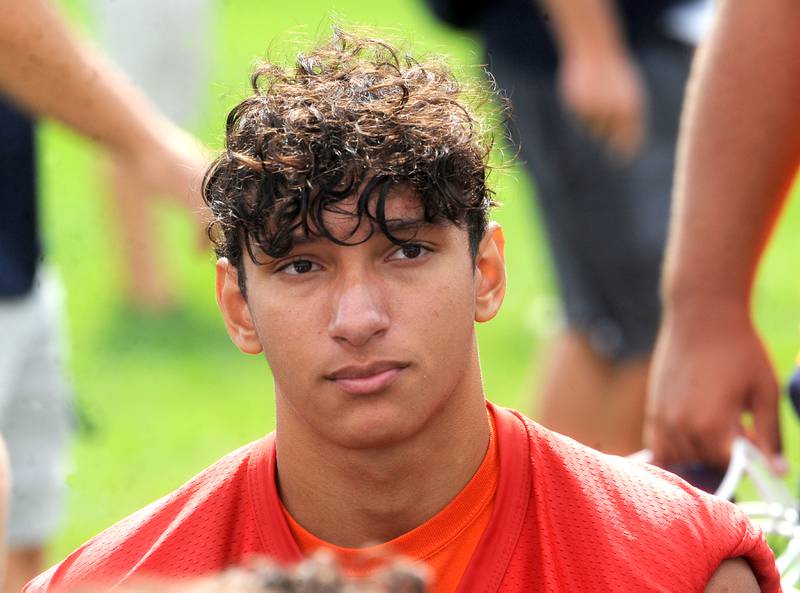 Oswego quarterback candidate Grant Zegar listens in to the coach after football practice at Oswego High School on Monday, Aug 7, 2023.