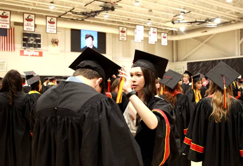 Batavia High School graduate Grace Bennett helps Will Adamczyk with his cap before the school’s 2024 commencement ceremony at Northern Illinois University in DeKalb on Wednesday, May 22, 2024.