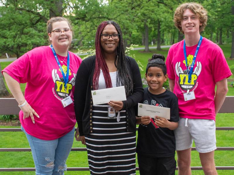 YEP 2.Pro committee members Steffini McDowell and Max Cryer present a $5,000 check to Family Service Agency employee Sha' Hill