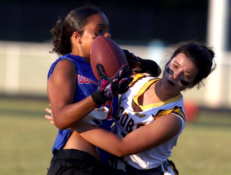 Dundee-Crown’s Taiyah Boddie Thomas, left, tussles with  Jacobs’  Ava Nisi for the ball in varsity flag football on Tuesday, Sept. 3, 2024, at Dundee-Crown High School in Carpentersville.