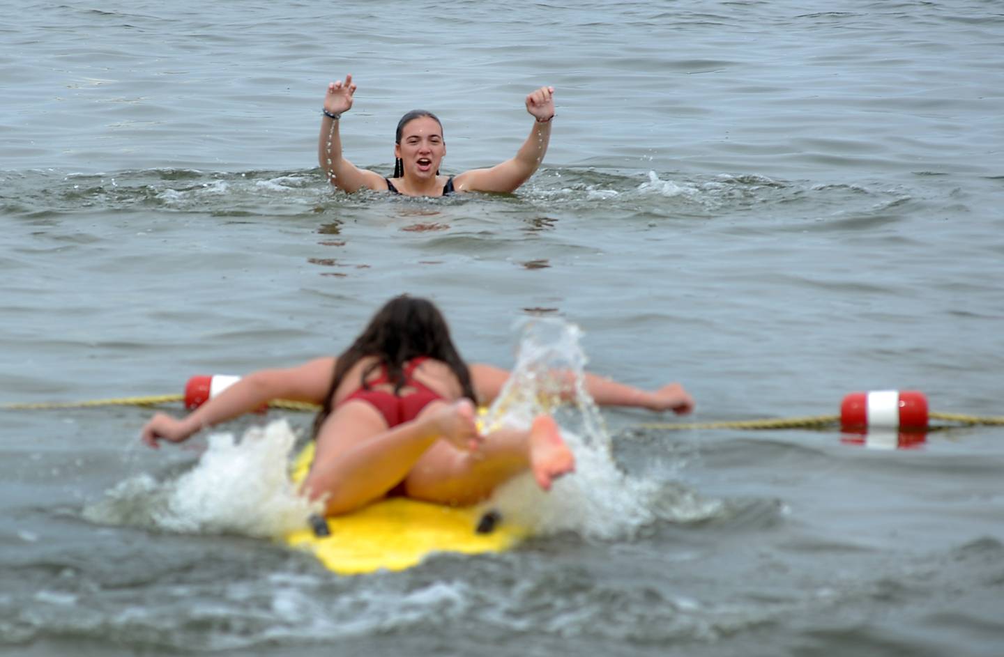 Mareena Berge paddles out to practice rescuing Avery Kuligowski Wednesday, June 1, 2022, during a lifeguard training session at Crystal Lake's Main Beach.