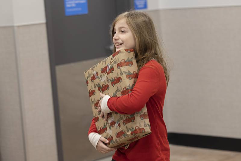 After meeting Santa Claus, Lilth Garcia, 9, heads off with a special gift Saturday, Dec. 10, 2022 at Dixon’s Walmart.