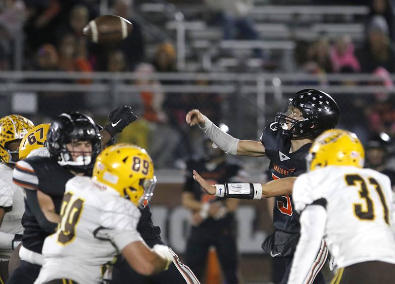 McHenry's Dayton Warren throws a pass as he is pressured by Jacobs' Charlie Glenn (left) and Blake Koziel (right) during a Fox Valley Conference football game on Friday, Oct. 18, 2024, at McKracken Field in McHenry.