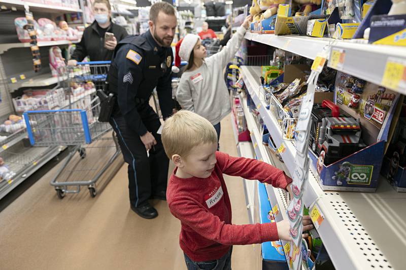 Ryker Bishop, 5, shops with Dixon officer Ryan Bivins and his daughter Marley, 9, Saturday, Dec. 10, 2022 in Dixon.