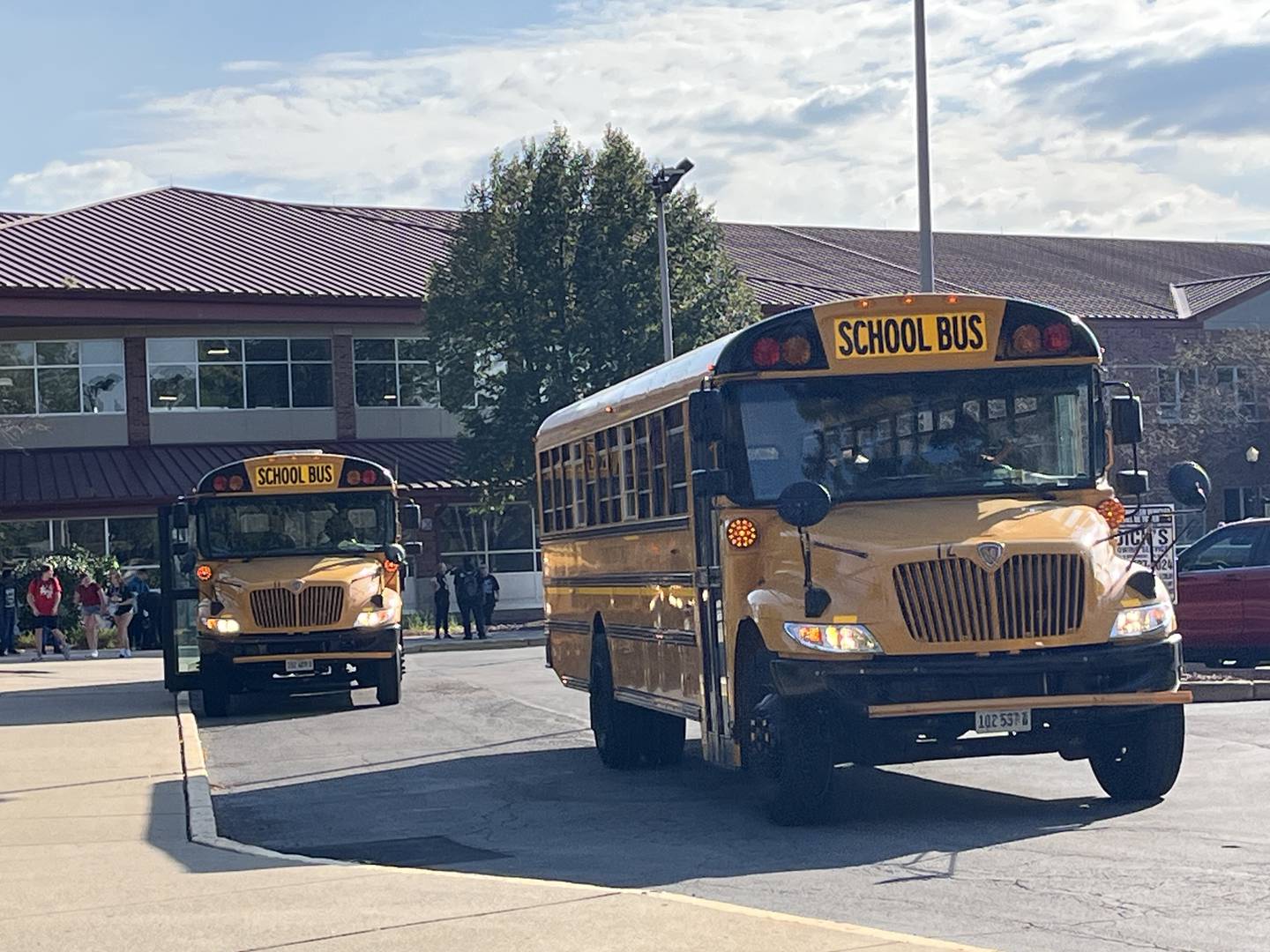 Buses leave Joliet West High School to take students home around an hour later than normal after the school was placed on a safety protocol after the school was notified of a rumor of a weapon on campus on Friday, Sept. 13, 2024.