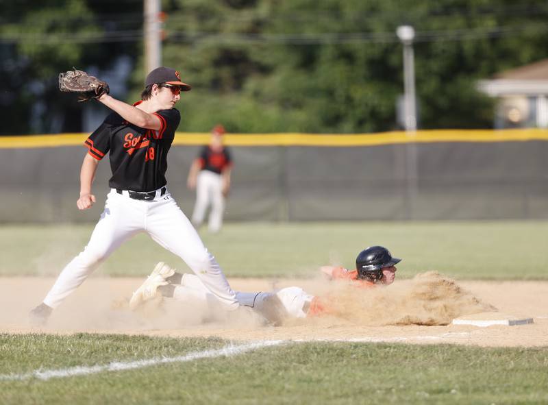 St. Charles East's Jake Greenspan (8) dives back into first on a pickoff attempt by Wheaton Warrenville South's Jacob Conover (18) during the Class 4A York regional semi-final between Wheaton Warrenville South and St. Charles East in Elmhurst on Thursday, May 23, 2024.