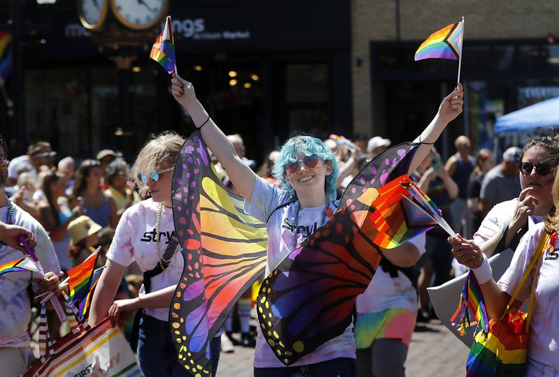 Casey Moffitt waves flags ask she marches with the Stryker group during the Woodstock PrideFest Parade on Sunday, June 9, 2024, around the historic Woodstock Square.