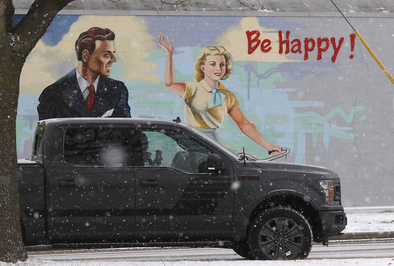 A motorist waits for a stoplight to change at the intersection of Dole Avenue and Route 14, as the snow falls Thursday, Dec. 22, 2022, during a winter storm hits northern Illinois.