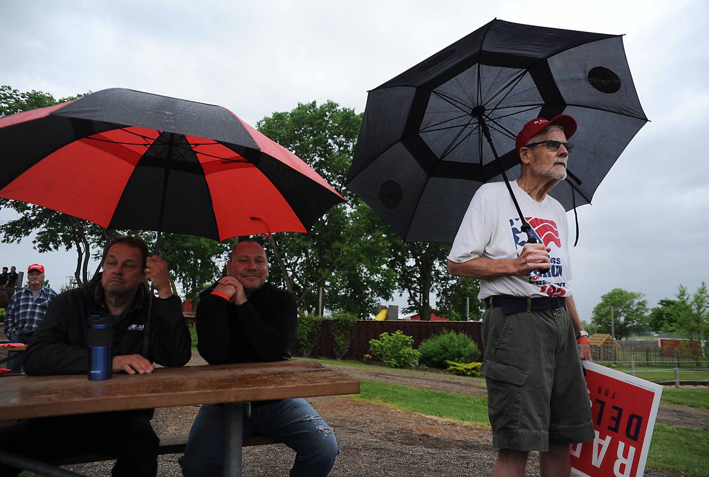 Larry Nelson, right, of McHenry, and others try to keep dry as they listen to the views of Republican gubernatorial candidates during the Grand Old Party at the Farm Forum on Saturday, June 4, 2022, at Richardson Farm, 909 English Prairie Road, in Spring Grove. The all day event forum featured Republican candidates up and down the ticket on multiple stages.