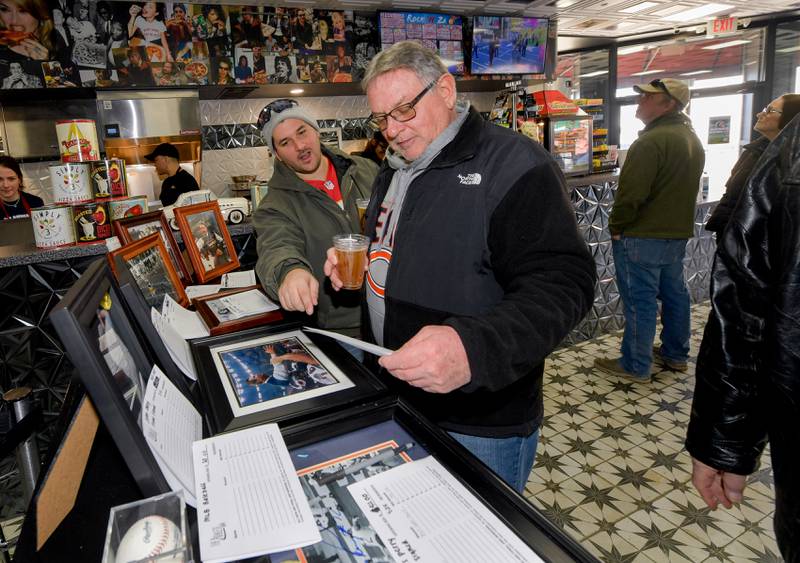 Jimmy and John Mathisen of Elgin bid on some autographed sports photographs during the Arcada Theatre’s “Mongo Bowl 23” to raise money for former Chicago Bears player Steve “Mongo” McMichael, who has ALS, on Sunday, Feb. 12, 2023.