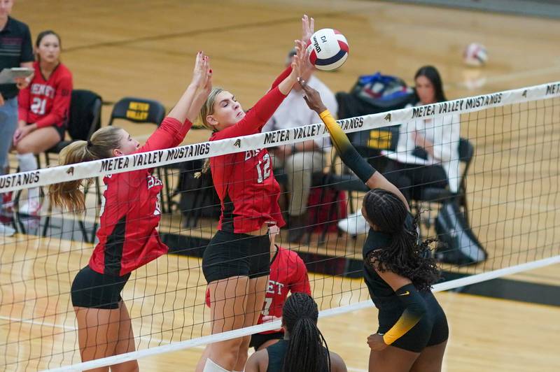 Benet’s  Lynney Tarnow (12) and Sophia Chinetti (15) defend the net against a kill attempt by Metea Valley's Olivia Stewart (8) during a volleyball match at Metea Valley High School in Aurora on Wednesday, Sep 4, 2024.