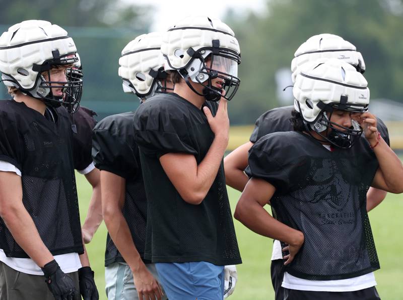 Kaneland’s Ryan Majerus (center) talks to teammates during a break at practice Friday, Aug. 16, 2024, at the school in Maple Park.