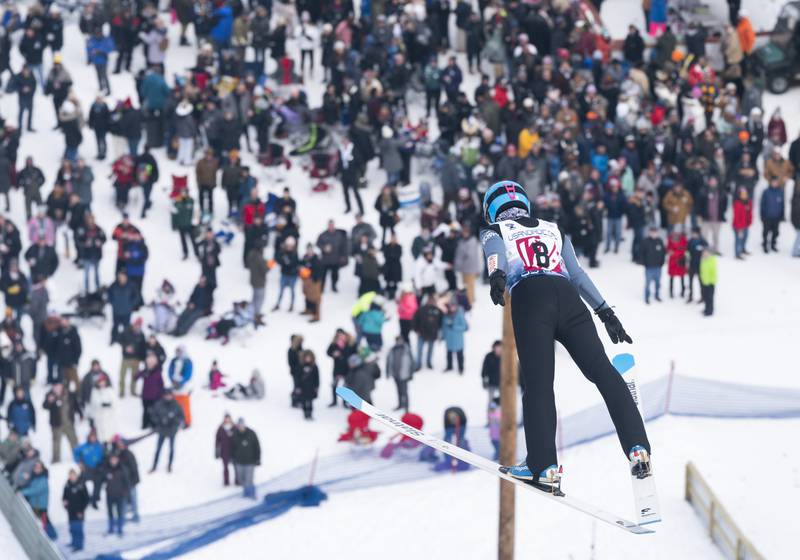 Sandra Sproch, with the Norge Ski Club, soars high above the crowd during the 117th annual Norge Winter Ski Jump Tournament on Sunday, Jan. 30, 2022 in Fox River Grove.