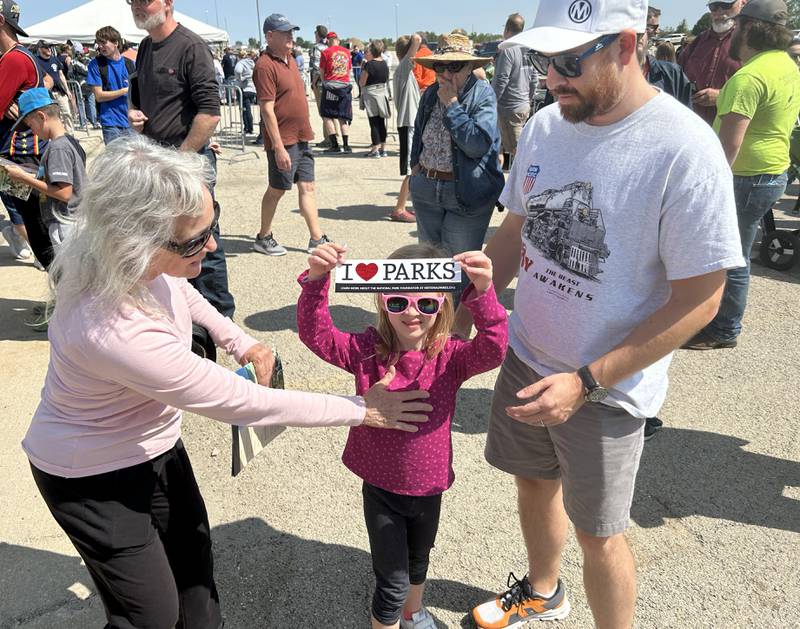 Sue McCormick of Crystal Lake and her granddaughter Maddie, 6, and her dad, Dan of Cary, checked out the National Parks coloring books and bumper stickers for kids at the Big Boy event in Rochelle on Sunday, Sept. 8, 2024.