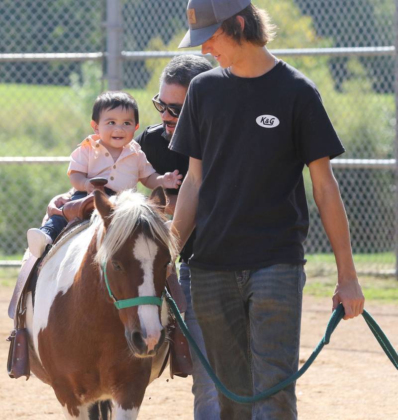 Luke Reynolds, 16, of Wadsworth, (on right) with Patch 22, gives a pony ride to Edgar Vargas, nine-months-old, of Round Lake Heights, as his father, Isaias, holds on to him during the Fall Festival at Grant Township Center on October 1st in Ingleside. The event was sponsored by the Village of Fox Lake and Grant Township.
Photo by Candace H. Johnson for Shaw Local News Network