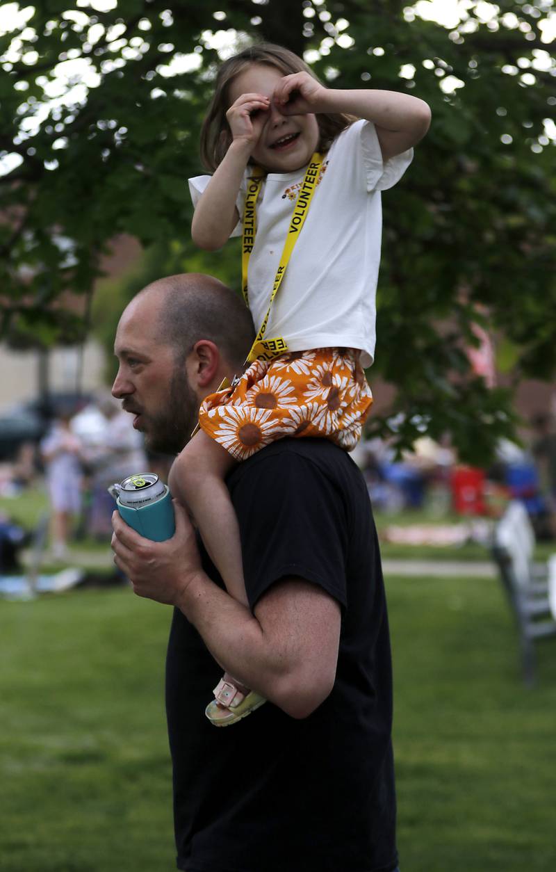 Georgiana Krause, 4, surveys the crowd as she rides on her dad, Aaron’s shoulder on Thursday, May 16, 2024, during McHenry's Pearl Street Market and concert at Veteran's Memorial Park. The market features around 35 venders and live music on Thursdays through Sept. 19. We I see this photograph, I can’t help but to think of “Hypnotized, mesmerized by what my eyes have seen” a lyric from a Natalie Merchant song. As Georgiana scans the crowd with her eyes.