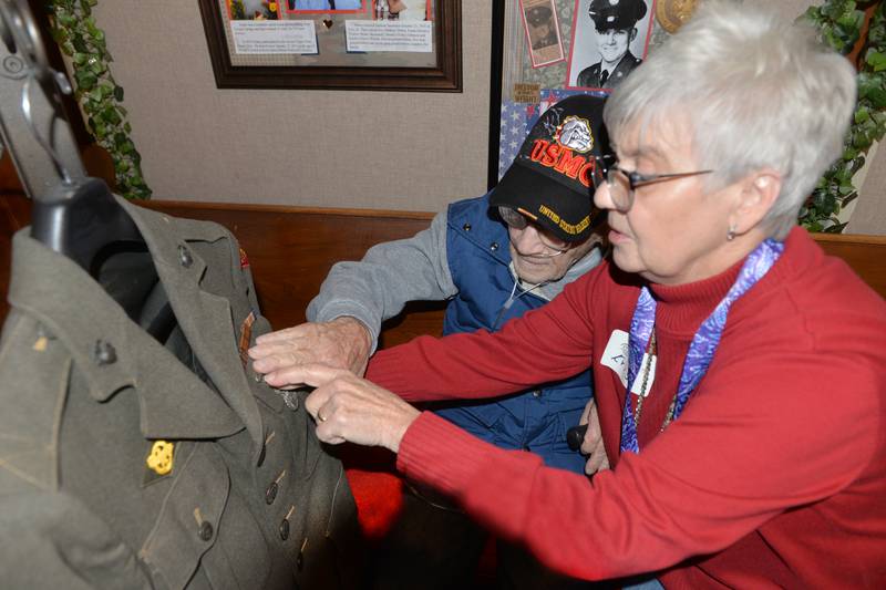 World War II Veteran Ken Pifke, 99, of Prophetstown, describes one of the medals he received when serving with the Marines in the South Pacific as he sits with daughter Kris Bielema at the Lyndon Area Historical Society's 8th annual Salute to Area Veterans on Sunday, Nov. 12, 2023. Visitors were able to view the "We Band of Brothers" display of Lyndon-area veterans who served their country.