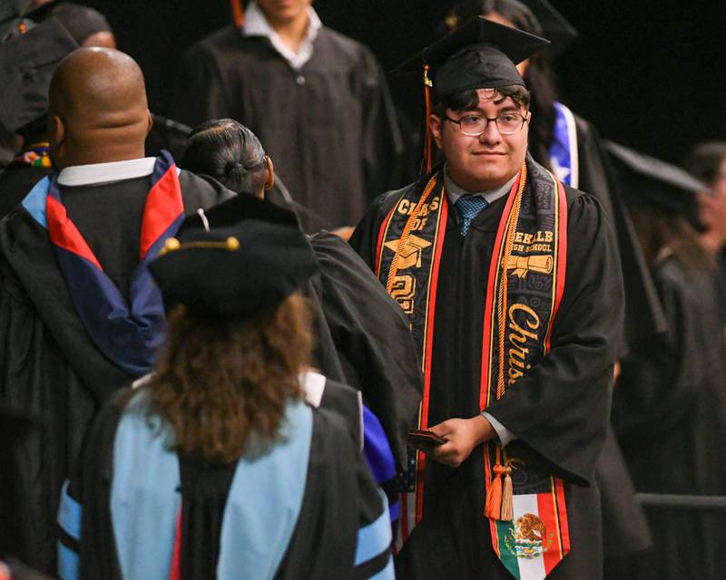 DeKalb High School senior Christopher Lopez gets congratulated as he collects his diploma during the 2024 DeKalb High School commencement ceremony on Saturday, May 25, 2024, at the Northern Illinois University Convocation Center in DeKalb.