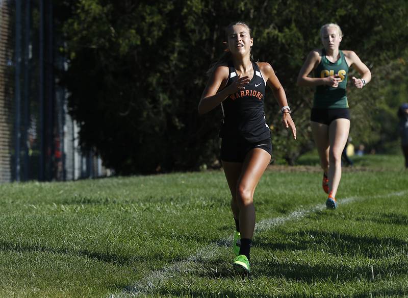 McHenry’s Danielle Jensen is chased by Crystal Lake South’s Abby Machesky during the girls race of the McHenry County Cross Country Meet Saturday, August 27, 2022, at Emricson Park in Woodstock.