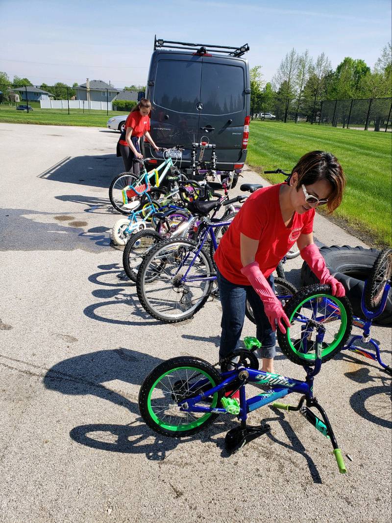 Volunteer fixing the tire on a children's bike during the 2023 bike clean up day.