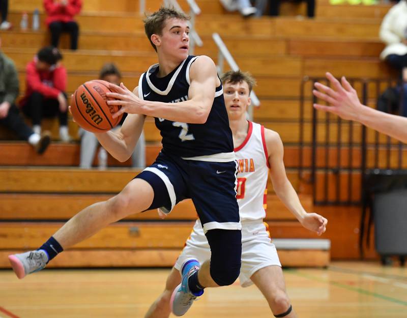 Downers Grove South's Will Potter (2) passes in front of Batavia's Nate Nazos during a Jack Tosh Classic game on Dec. 26, 2023 at York High School in Elmhurst.