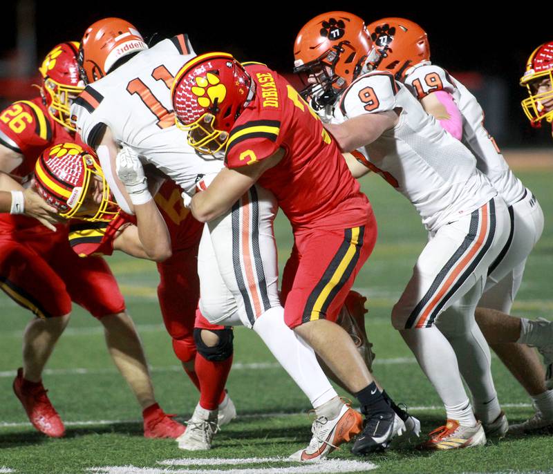 Batavia’s Drew DiBiase (right) tackles Wheaton Warrenville South’s Zach Rogers on Friday, Oct. 18, 2024 during a game at Batavia.