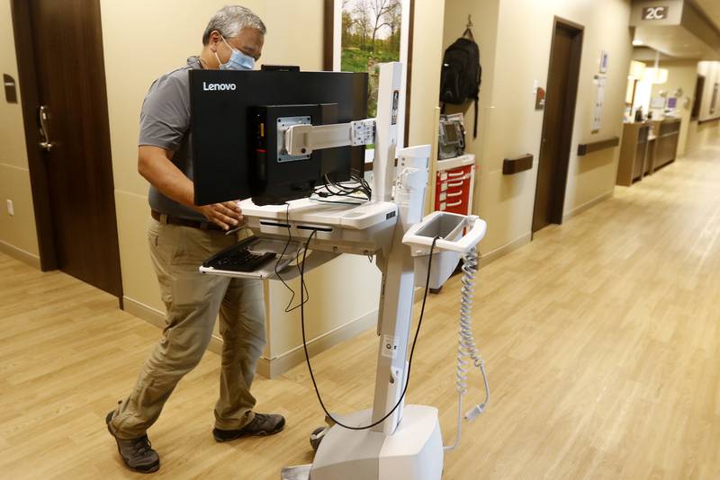 Pulmonologist and critical care specialist Dr. Daniel Nepomuceno wheels out computer charts to a patient room at Northwest Medicine Huntley Hospital on Wednesday, June 23, 2021, in Huntley.