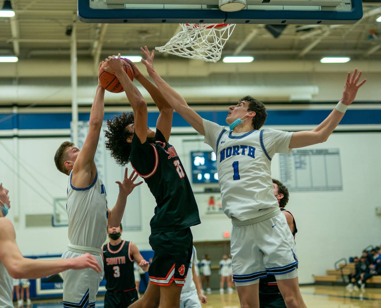 St. Charles North's Jude Love (5) and Ethan Marlowe (1) defend the paint against Wheaton Warrenville South's Bray Meredith (25) during a basketball game at St. Charles North High School on Friday, Jan 21, 2022.