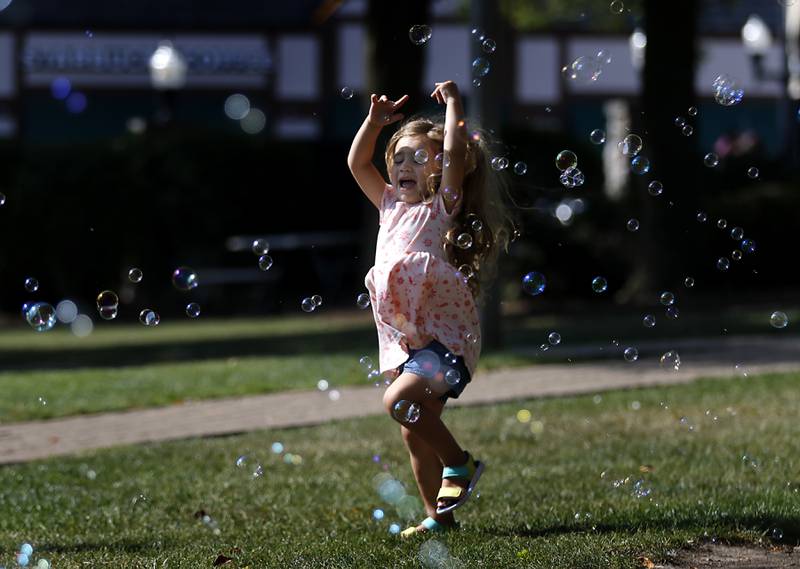 Evelyn Barajas, 4, of Woodstock plays in the bubbles on Tuesday, Aug. 27, 2024, during the Summer Woodstock Farmers Market around the Historic Woodstock Square. People were able to shop from over 40 of their favorite farms & producers for in-season food fresh produce, dairy, meats, breads, baked goods, spices, herbs, pasta, flowers and more.