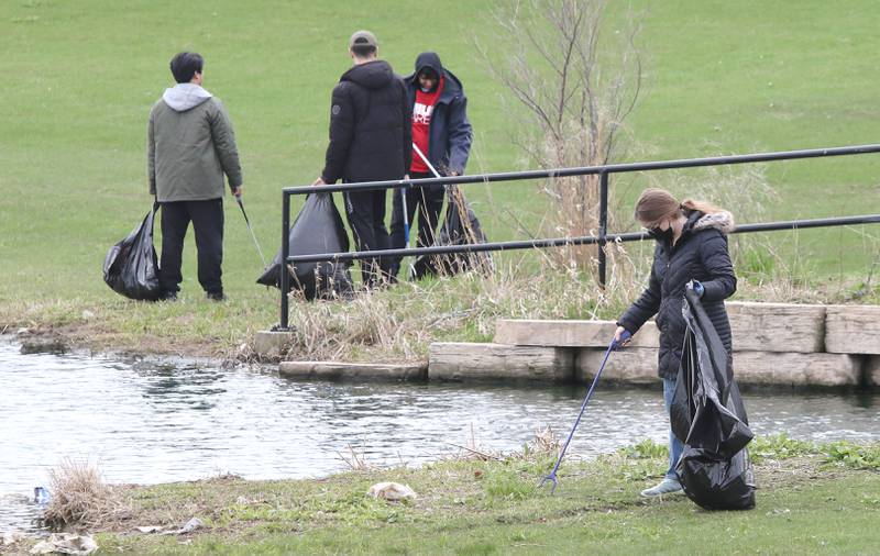 Northern Illinois University students with NIU Cares pick up garbage on campus Friday, April 29, 2022, around the West Lagoon. NIU Cares, with the help of the Trash Squirrels, was hosting a community cleanup event, going to several locations in DeKalb to pick up litter.