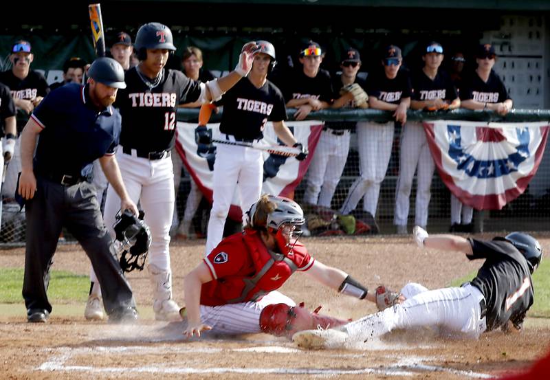 Crystal Lake Central's Drew Welder slides into home plate as Deerfield's Ethan Platt tries to tag him during a Class 3A Grayslake Central sectional championship baseball game on Friday, May 31, 2024, at the Grayslake Central High School.